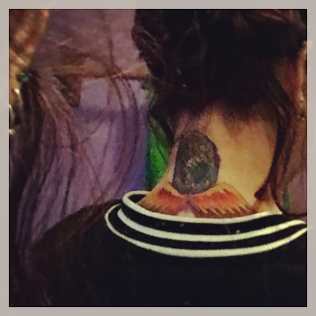 A picture of a tattoo on the back of a person's neck.