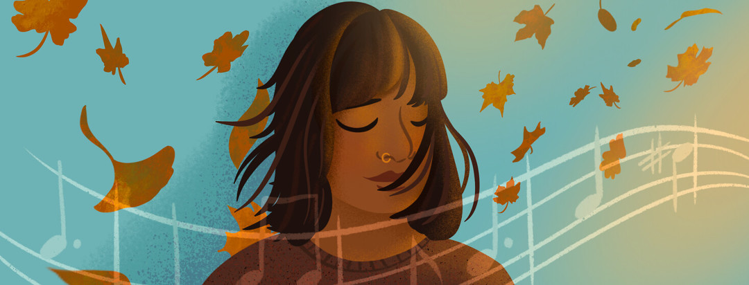 Southeast Asian woman closes her eyes while enjoying music and autumn breeze