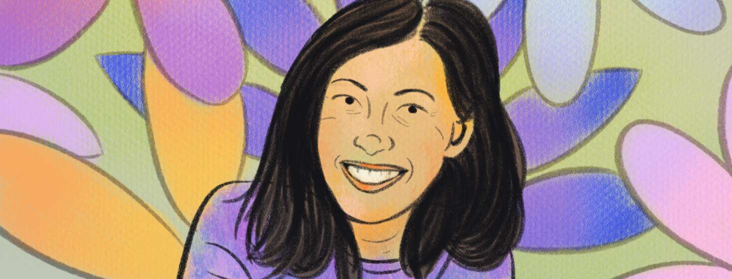 Comedian Kim Evey smiling among bright large flower petals