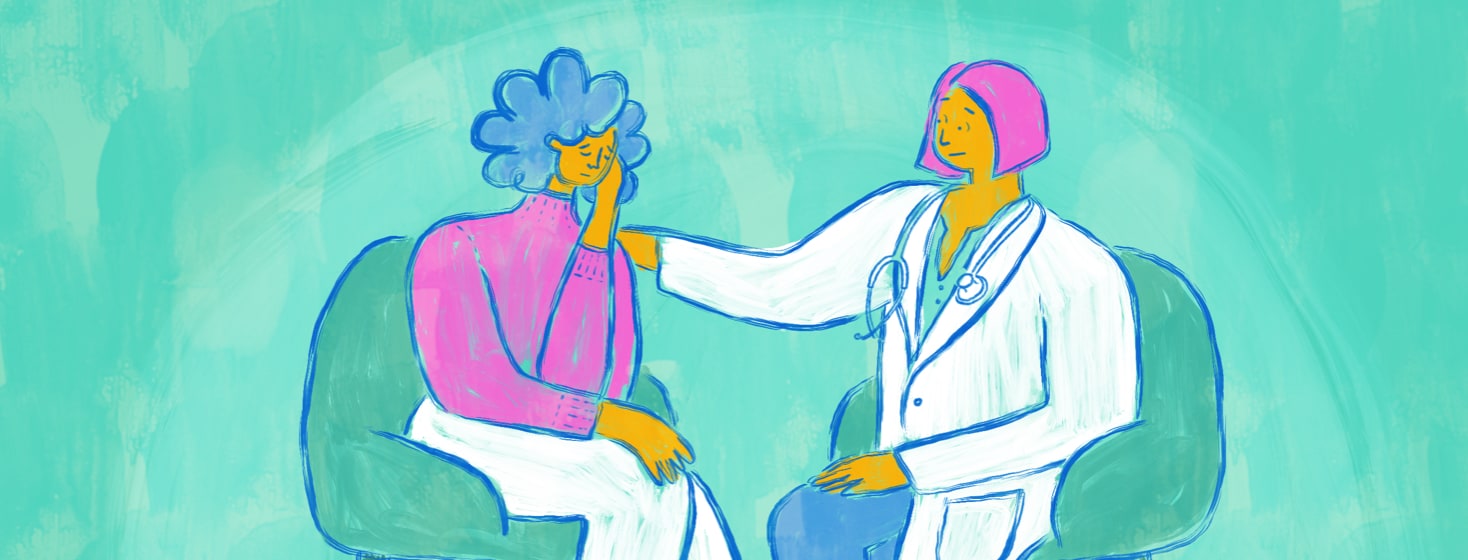 A doctor offers a comforting hand on the shoulder of a patient holding their head.