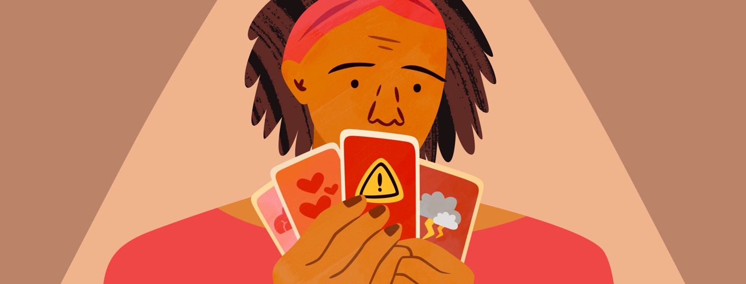 Woman holding up playing cards with different symbols of her emotional state on them